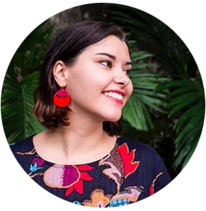 Trish wearing a colourful dress and matching earrings. Meet the maker Mikmat Designs